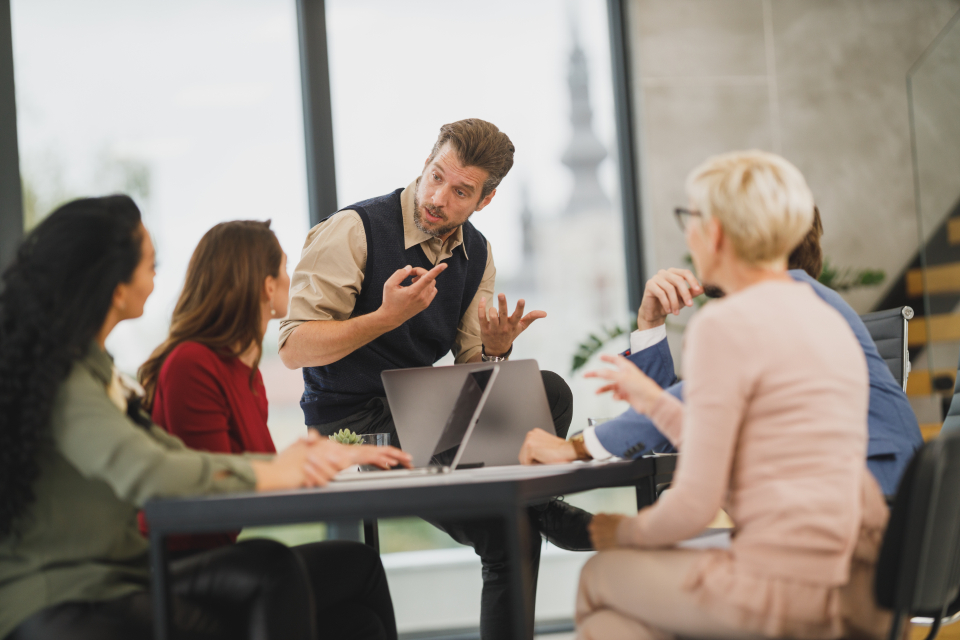 Professionals in a workplace meeting practicing business English as non-native speakers