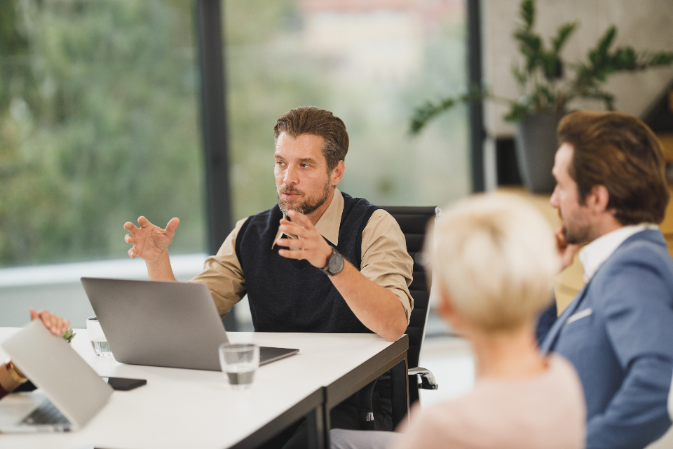 Business team meeting around a table, where business Spanish skills build client relationships