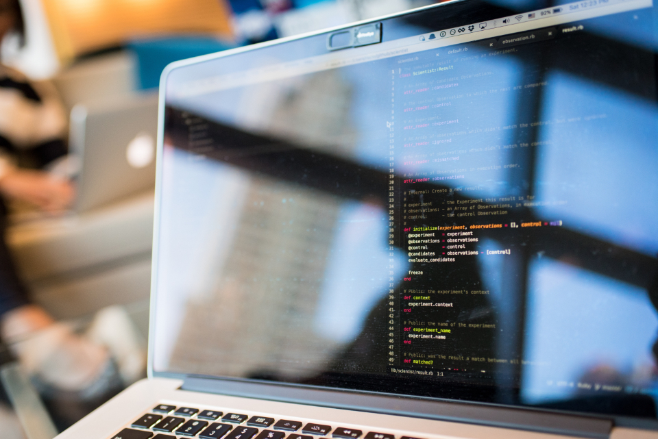 Software developer coding on a laptop during onboarding at a multilingual tech team